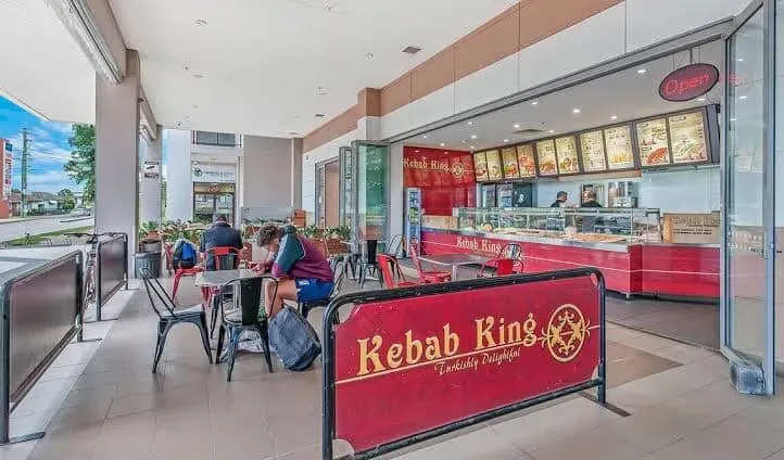 The Kebab King counter and red sign at Market Plaza, with tables out front
